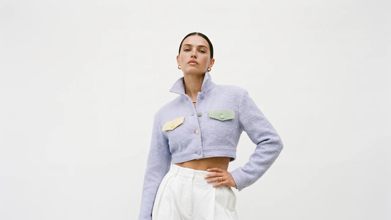A model in a cropped lilac jacket with pastel pockets, on the house's light ground